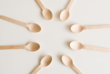 High angle view of bamboo spoons arranged in a circle on white table