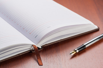 Open notebook with a pen on the table.