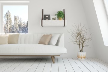 White room with sofa and winter landscape in window. Scandinavian interior design