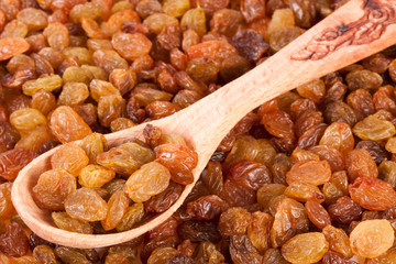 raisins with a wooden spoon as background