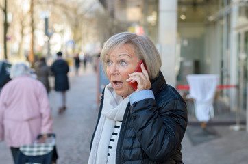 Woman shocked talking by the phone