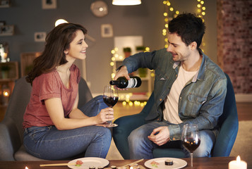Boyfriend serving red wine while date .