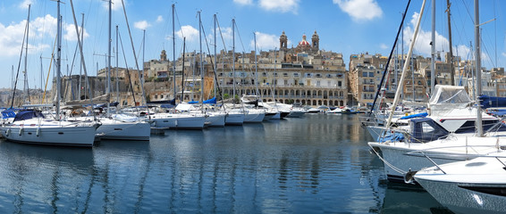 The view of yachts moored in harbor in Dockyard creek with Singlea peninsular on background. Malta
