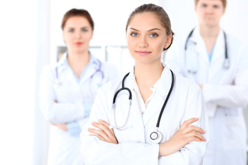 Fototapeta premium Happy female doctor with medical staff at the hospital. Successful team at health care concept
