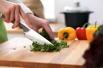 Closeup of human hands cooking vegetables salad in kitchen on the glass table with reflection. Healthy meal and vegetarian concept