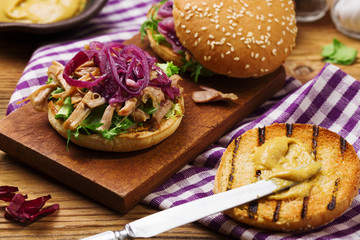 Burger with meat of duck with red onion and lettuce.