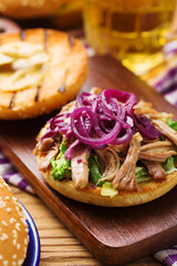 Burger with meat of duck with red onion and lettuce.