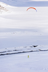 people doing kitesurfing on a frozen mountain lake