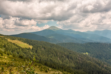 Fototapeta premium Summer landscape in mountains and the dark blue sky with clouds