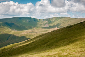 Summer landscape in mountains and the dark blue sky with clouds