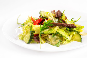 Plate of fresh vegetables salad with meat isolated at white background.