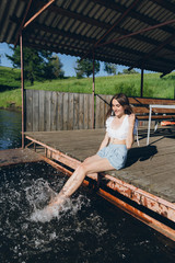 Girl dipping feet in the water and laughing