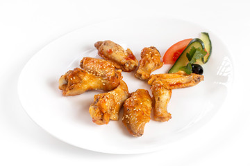 Plate of fried golden chicken wings and legs isolated at white background.