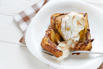 Delicious homemade dessert. Baked toast with apples and ice cream drizzled with chocolate