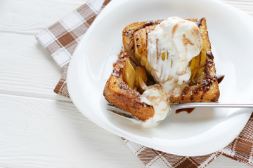 Delicious homemade dessert. Baked toast with apples and ice cream drizzled with chocolate