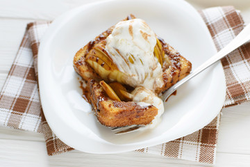 Delicious homemade dessert. Baked toast with apples and ice cream drizzled with chocolate