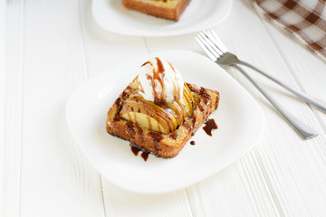 Delicious homemade dessert. Baked toast with apples and ice cream drizzled with chocolate