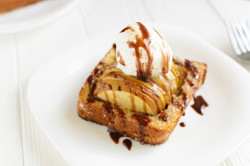 Delicious homemade dessert. Baked toast with apples and ice cream drizzled with chocolate