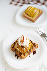 Delicious homemade dessert. Baked toast with apples and ice cream drizzled with chocolate