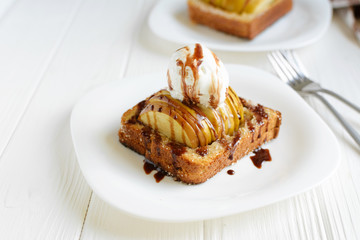 Delicious homemade dessert. Baked toast with apples and ice cream drizzled with chocolate