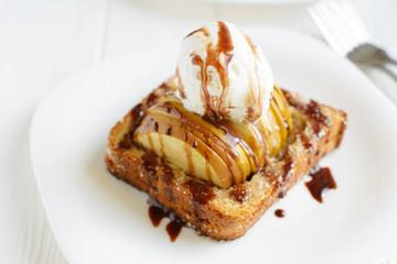 Delicious homemade dessert. Baked toast with apples and ice cream drizzled with chocolate