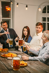 Group of friends enjoying evening drinks with beer