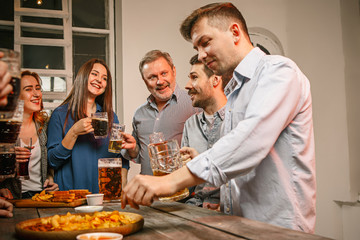 Group of friends enjoying evening drinks with beer