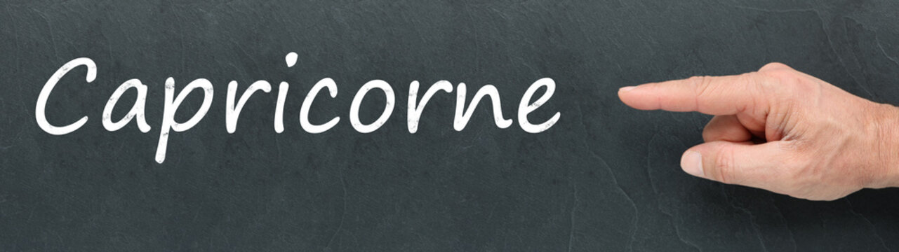 Capricorne &agrave; la craie et montrer du doigt sur ardoise. Signes du zodiaque