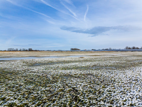 Last Snow covering field and grass under sky