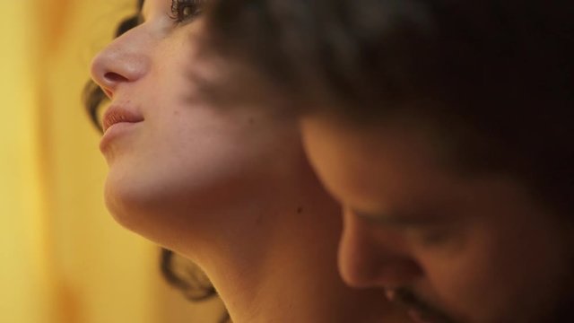 sex scene: woman thoughtful while her boyfriend touches her sensually