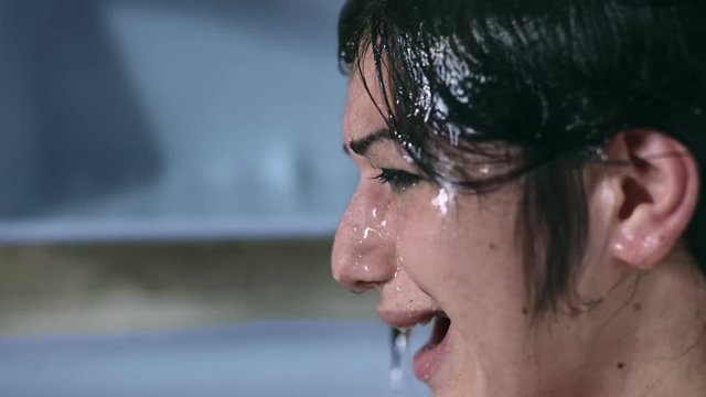 Profile of sad and desperate woman crying in the shower