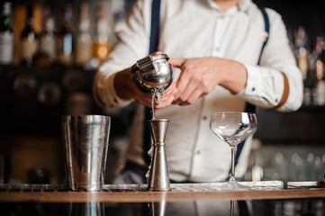 Bartender in white shirt making coctail