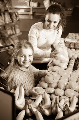 Fototapeta na wymiar Mother and child purchasing mandarins in market