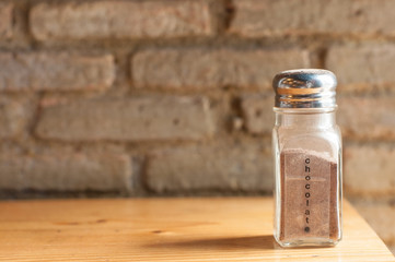 Bottles of coffee ingredients on wooden bar with grunge brick block wall.