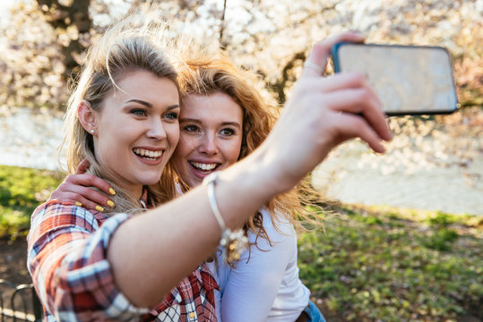 Two beautiful women taking a funny selfie