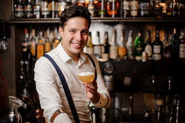smiling barman holding coctail at the bar stand