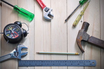 Worker tool equipment adjustable wrench hammer on wooden floor.
