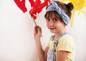 Obraz na płótnie Canvas Girl draws paints on the wall