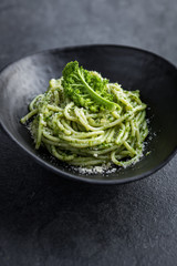 spaghetti pasta with  kale pesto sauce and parmesan cheese