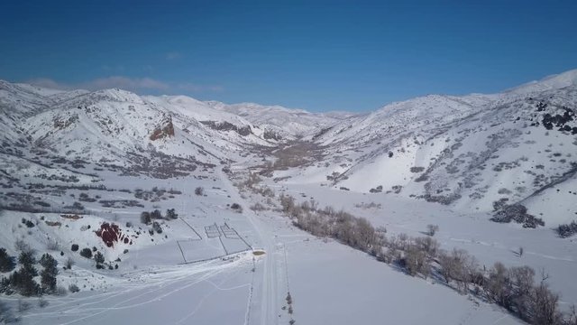 Aerial flight descent winter snow mountain valley. Winter snow on landscape of central Utah. Cold season weather. Nature and environment. Beautiful natural environment. Drone flight.