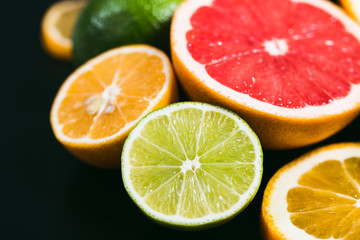 Fototapeta na wymiar Fresh citrus stihli. Lemons, limes, grapefruit and orange on a black background