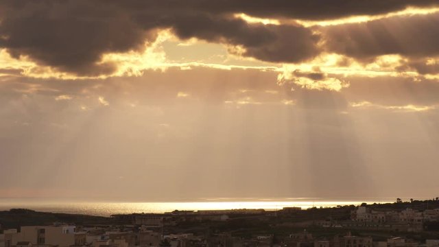sun rays coming out from the clouds and light up the sea