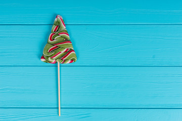 Lollipop as a Christmas Tree on wooden turquoise board