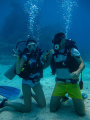 Young couple on the seafloor while diving