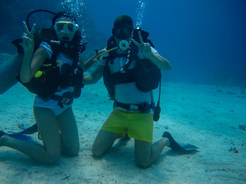 Young pair on the seafloor while diving