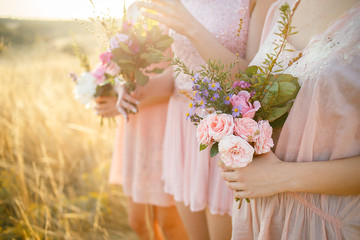 bridesmaids in pink dresses with bouquets - obrazy, fototapety, plakaty