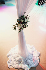 beautiful white and claret flowers decorate the wedding arch
