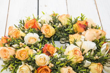 Wedding wreath with roses on white wooden background
