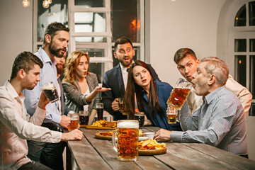 Group of friends enjoying evening drinks with beer