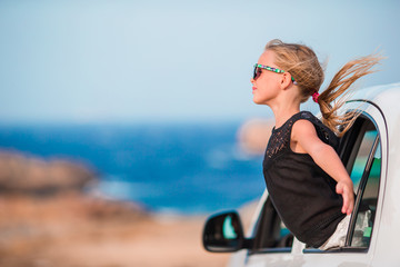 Little girl on vacation travel by car background beautiful landscape